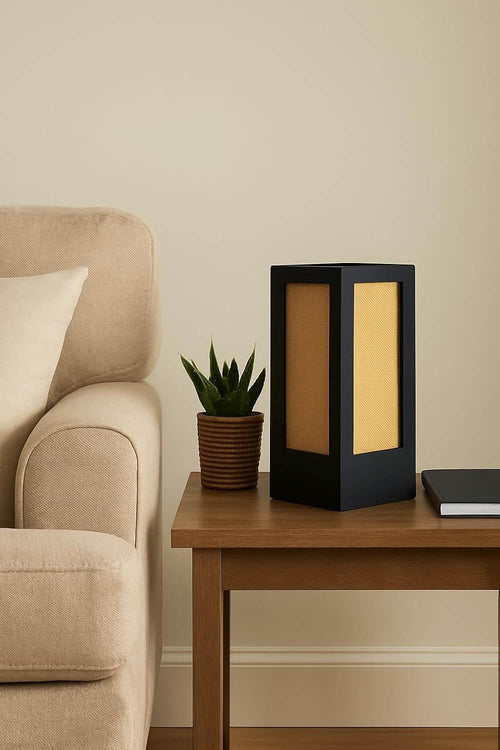 Wooden bedside table lamp with natural jute shade on a side table next to a plant and a notebook.